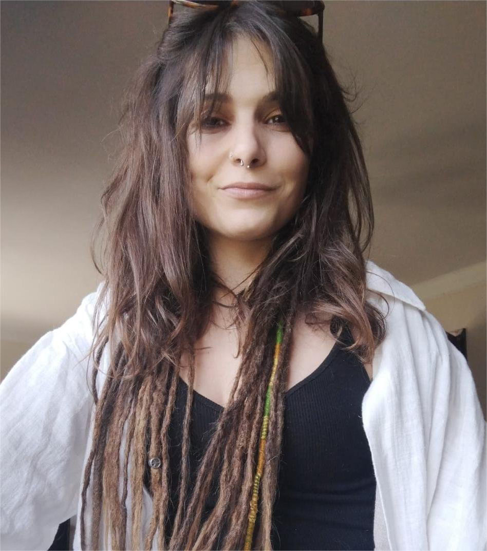 Portrait of a man with brown hair and glasses on a flat gray background.